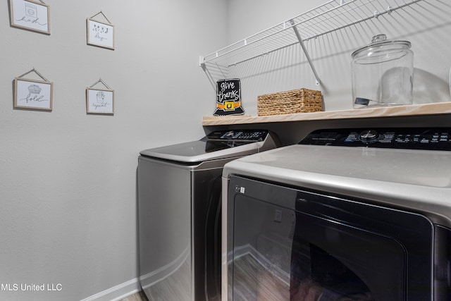 laundry area featuring washing machine and clothes dryer and hardwood / wood-style floors