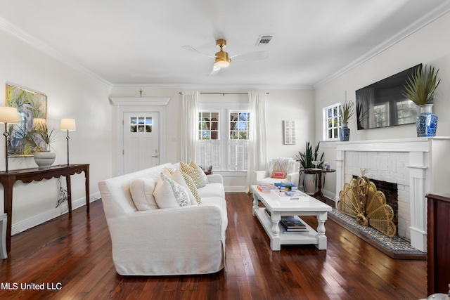 living room featuring dark wood-type flooring, crown molding, a fireplace, and ceiling fan