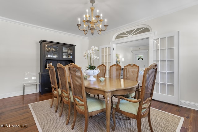 dining space featuring baseboards, an inviting chandelier, ornamental molding, and wood finished floors