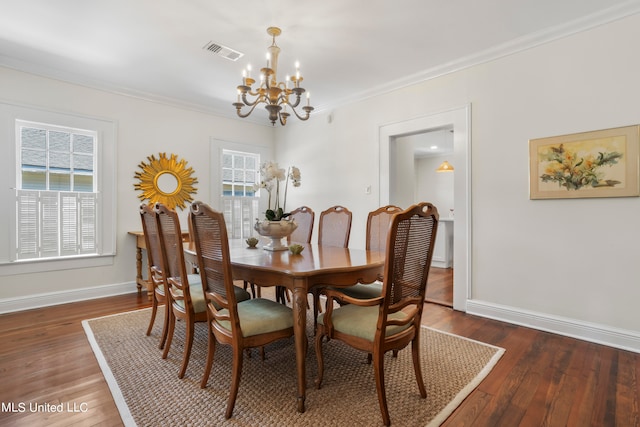 dining space featuring ornamental molding, a chandelier, and dark hardwood / wood-style floors