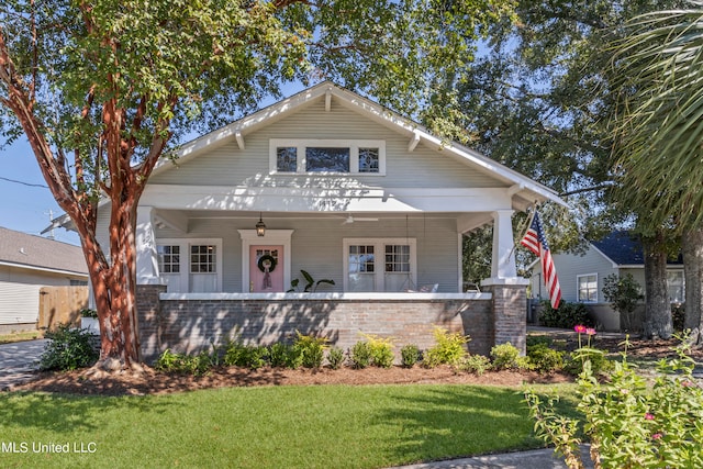 bungalow with covered porch and a front lawn