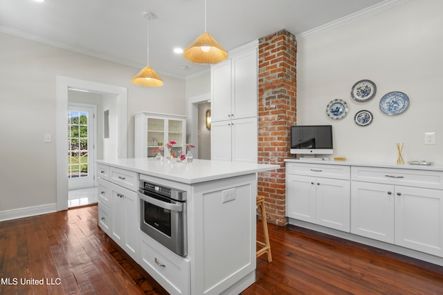 kitchen with white cabinets, hanging light fixtures, a kitchen island, stainless steel oven, and dark hardwood / wood-style floors