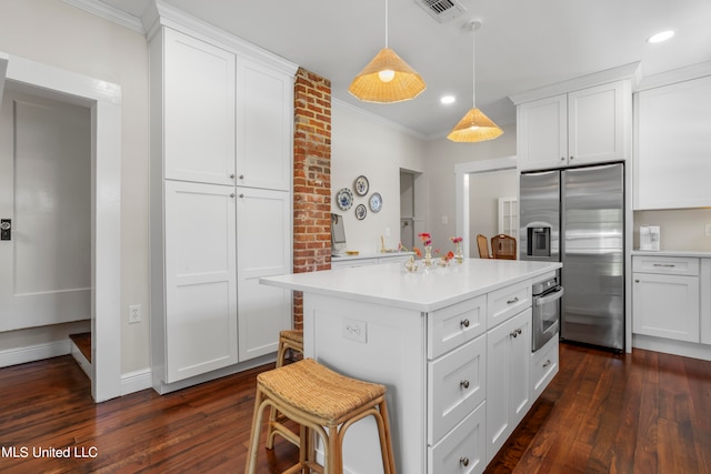 kitchen with dark wood-type flooring, appliances with stainless steel finishes, and white cabinetry