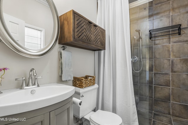 bathroom featuring toilet, tiled shower, and vanity