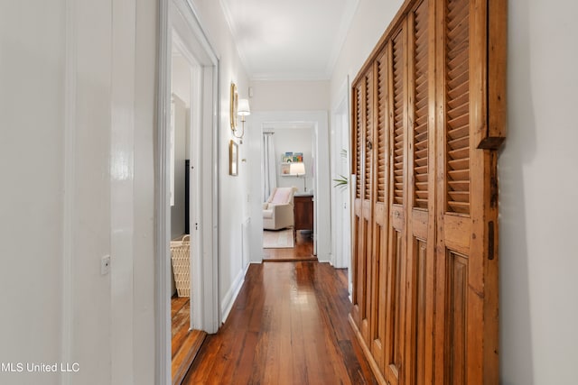 hall featuring ornamental molding and dark hardwood / wood-style flooring