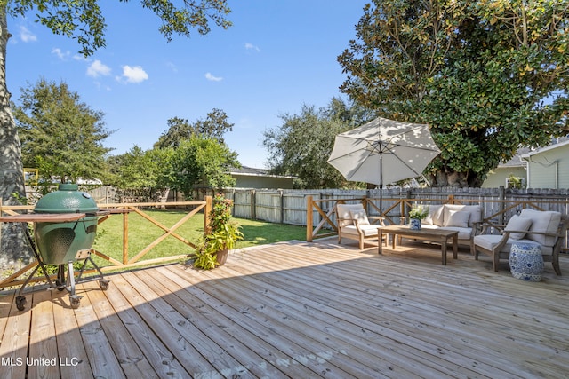 deck with outdoor lounge area, a yard, and a grill