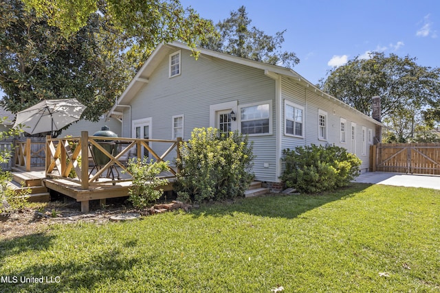 back of house with a lawn, a gate, a wooden deck, and fence