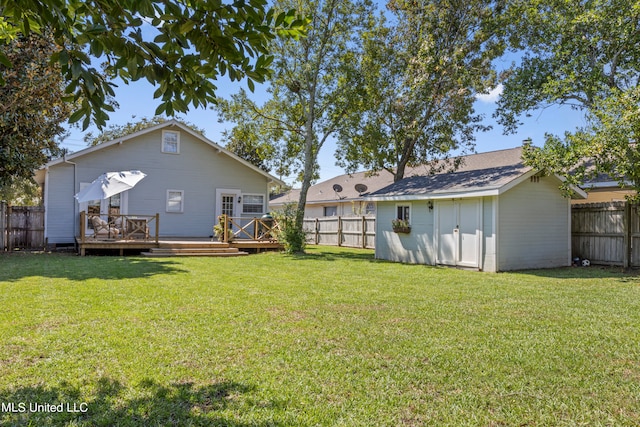 rear view of house featuring a wooden deck, a storage shed, and a lawn