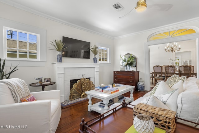 living area featuring visible vents, wood finished floors, a healthy amount of sunlight, and a fireplace