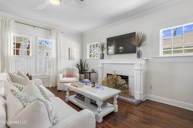 living room featuring crown molding, baseboards, a brick fireplace, and wood finished floors