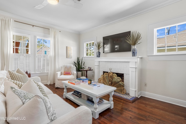 living room with ornamental molding, a wealth of natural light, a brick fireplace, and dark hardwood / wood-style floors