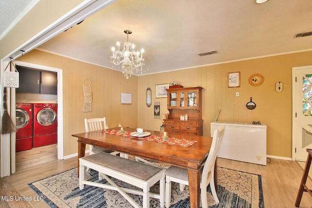 719 Holly Hills Dr, Biloxi, MS 39532 - dining area with separate washer and dryer, crown molding, light wood finished floors, a chandelier, and a textured ceiling