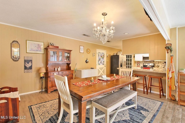 719 Holly Hills Dr, Biloxi, MS 39532 - dining area featuring a chandelier, light wood-style flooring, and ornamental molding