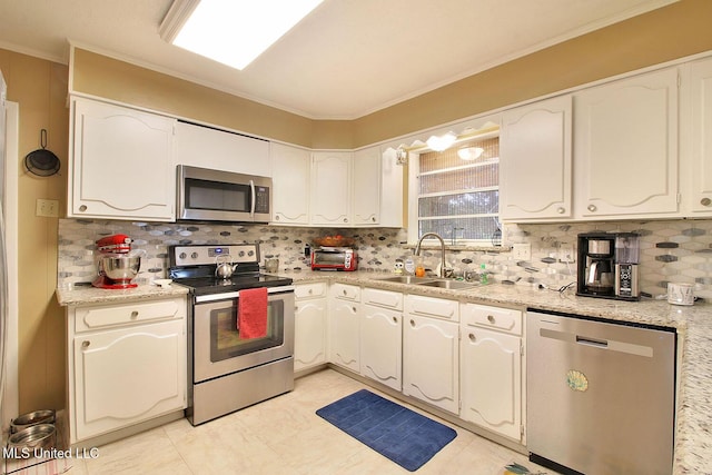 719 Holly Hills Dr, Biloxi, MS 39532 - kitchen with appliances with stainless steel finishes, backsplash, white cabinetry, and ornamental molding
