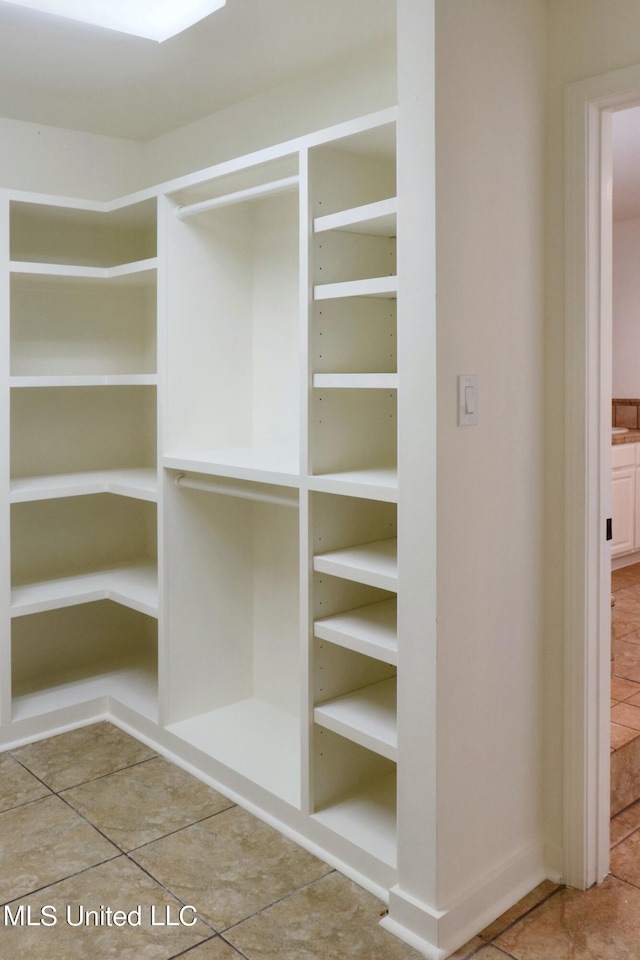 walk in closet with tile patterned flooring