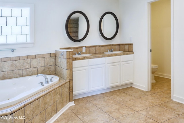 bathroom with vanity, toilet, tiled bath, and tile patterned flooring