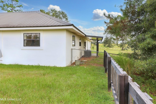 view of home's exterior featuring central AC and a yard