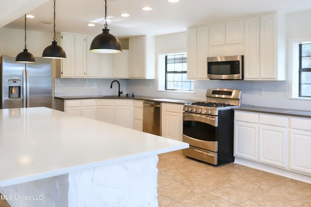 kitchen with white cabinetry, a healthy amount of sunlight, appliances with stainless steel finishes, and pendant lighting