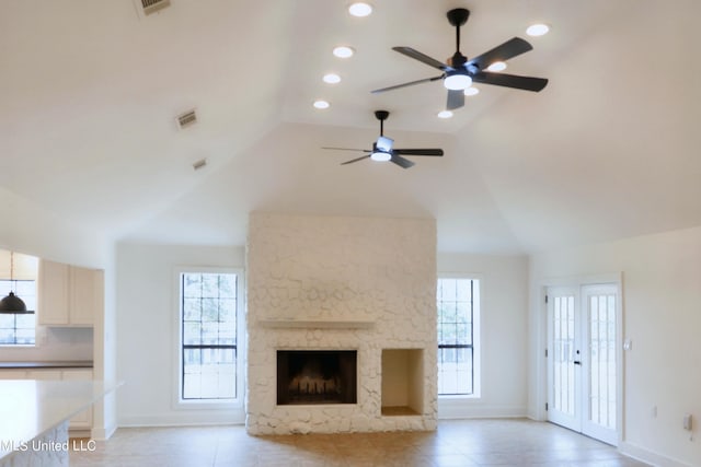 unfurnished living room with a fireplace, high vaulted ceiling, and ceiling fan