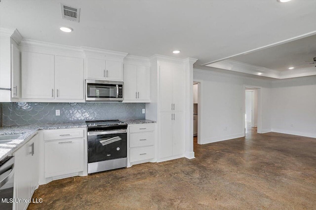 kitchen with white cabinets, appliances with stainless steel finishes, tasteful backsplash, and light stone countertops