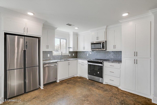 kitchen featuring white cabinets, appliances with stainless steel finishes, light stone counters, and sink