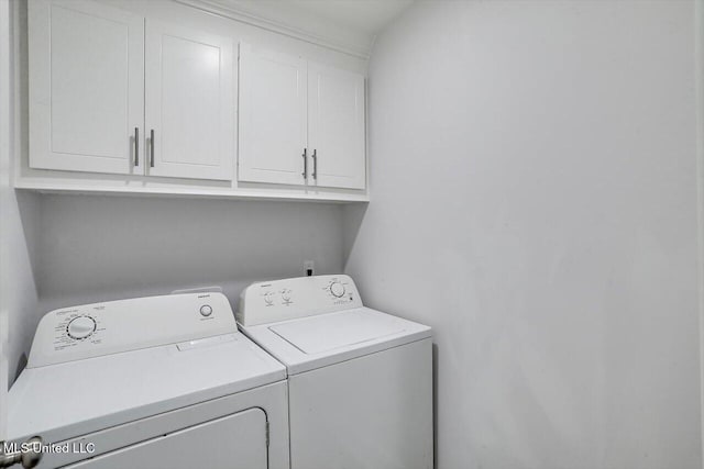 washroom with cabinets and washer and clothes dryer