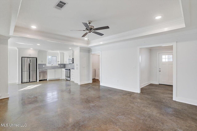 unfurnished living room with ceiling fan, ornamental molding, and a tray ceiling