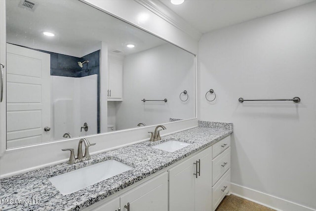 bathroom featuring a shower and vanity