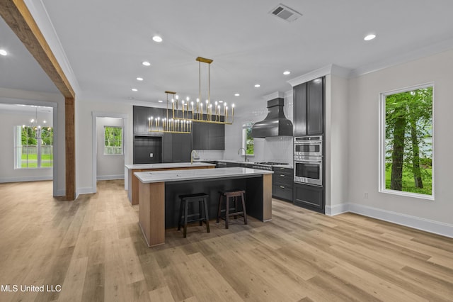 104 Westlake Cir W, Madison, MS 39110 - kitchen with range hood, a spacious island, a chandelier, appliances with stainless steel finishes, and crown molding