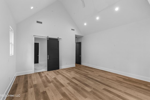 104 Westlake Cir W, Madison, MS 39110 - unfurnished bedroom featuring a barn door, high vaulted ceiling, light wood-style floors, and recessed lighting