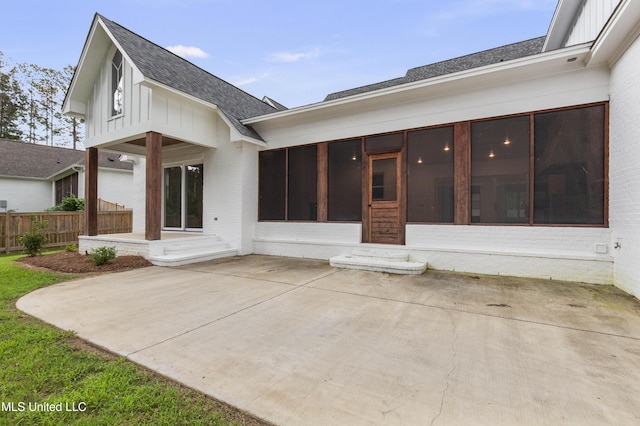 104 Westlake Cir W, Madison, MS 39110 - back of property featuring a sunroom, roof with shingles, brick siding, and a patio area