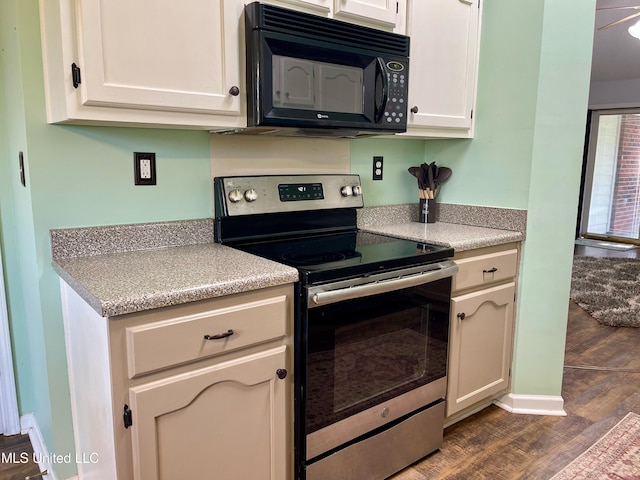 5306 Kristy Ln, Southaven, MS 38671 - kitchen with black microwave, stainless steel electric range, dark wood-style flooring, light countertops, and white cabinets