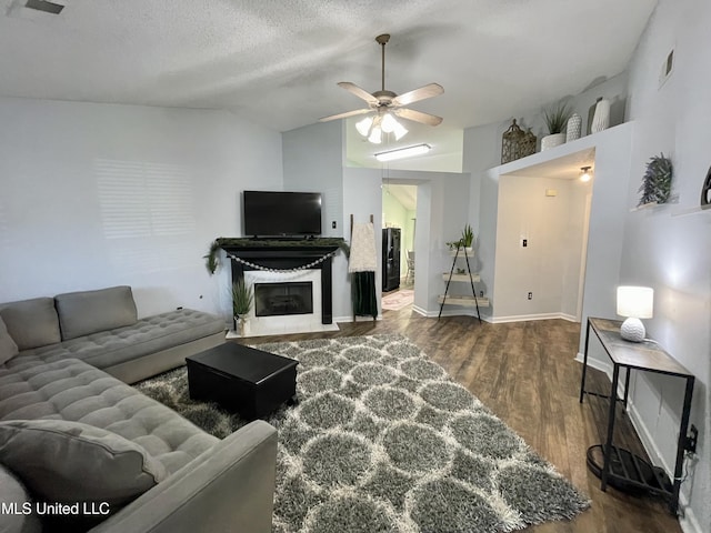 5306 Kristy Ln, Southaven, MS 38671 - living area featuring wood finished floors, vaulted ceiling, a ceiling fan, a fireplace with flush hearth, and a textured ceiling