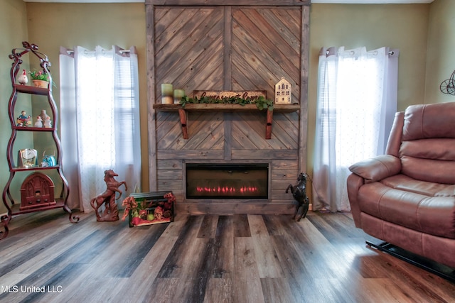 sitting room with hardwood / wood-style flooring, a healthy amount of sunlight, and wooden walls