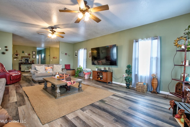 living room featuring wood-type flooring, a textured ceiling, and ceiling fan