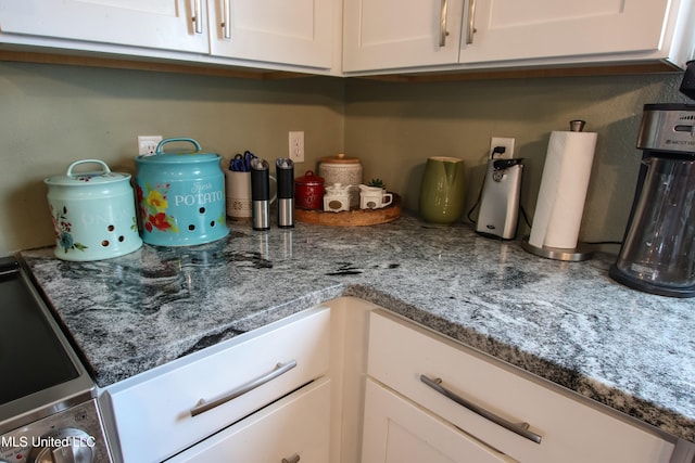 kitchen featuring white cabinetry and light stone countertops