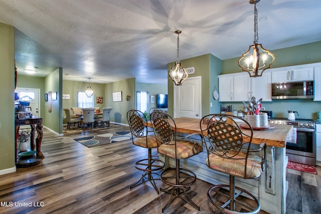 dining room featuring dark hardwood / wood-style floors, a textured ceiling, and a chandelier