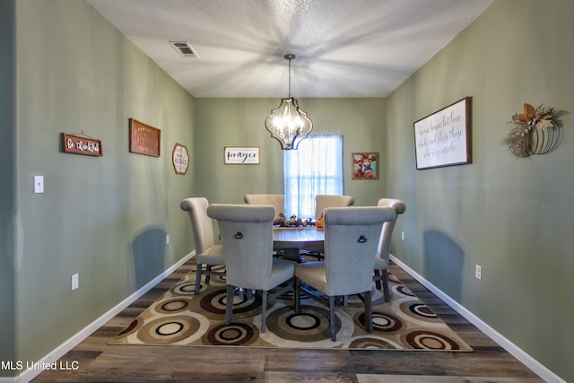 dining room with hardwood / wood-style floors and a notable chandelier