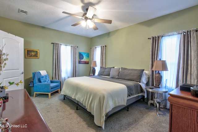 bedroom with carpet flooring, multiple windows, and ceiling fan