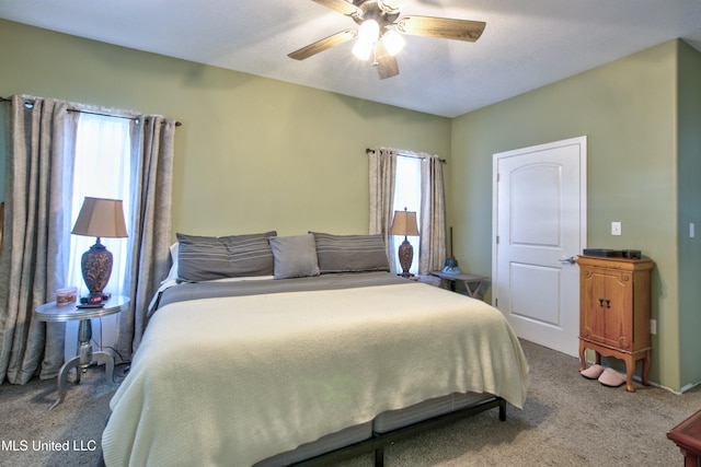 bedroom with multiple windows, ceiling fan, and carpet floors