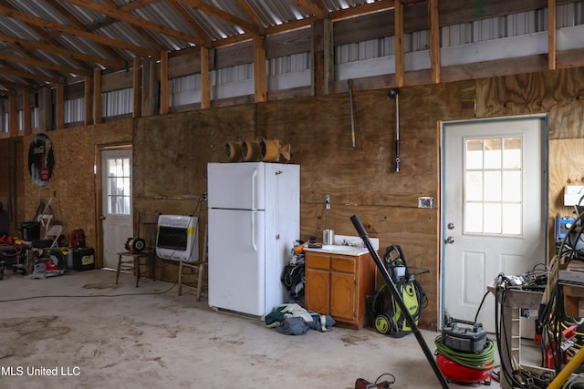 garage with heating unit and white fridge