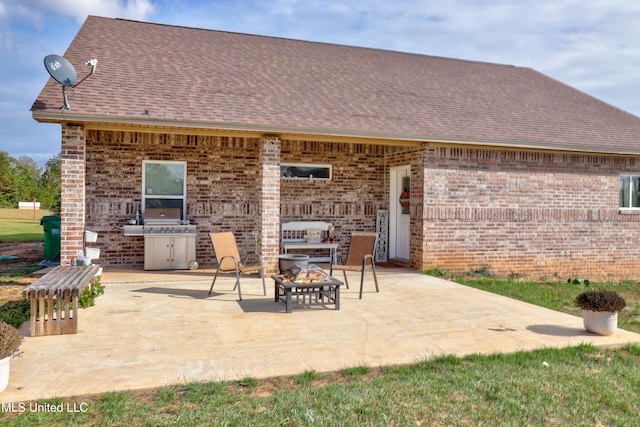 rear view of property with a fire pit and a patio area