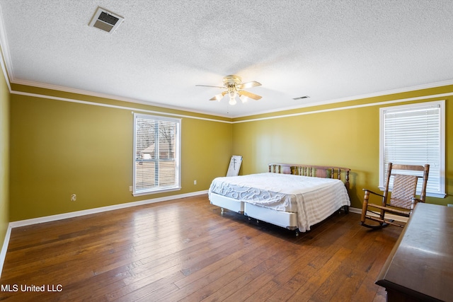 bedroom featuring ornamental molding, baseboards, visible vents, and hardwood / wood-style floors