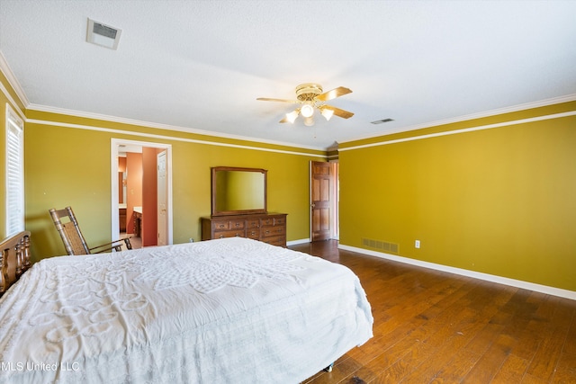 bedroom featuring ornamental molding, hardwood / wood-style flooring, visible vents, and baseboards