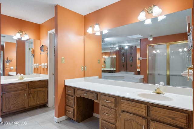 full bath with two vanities, a sink, a shower stall, and tile patterned floors