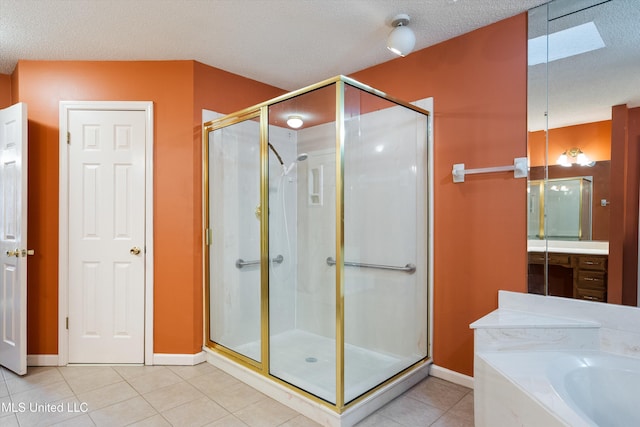 full bathroom with a textured ceiling, tile patterned flooring, baseboards, a bath, and a stall shower