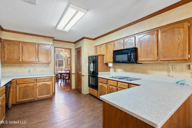 kitchen featuring a peninsula, black appliances, light countertops, and dark wood-style flooring