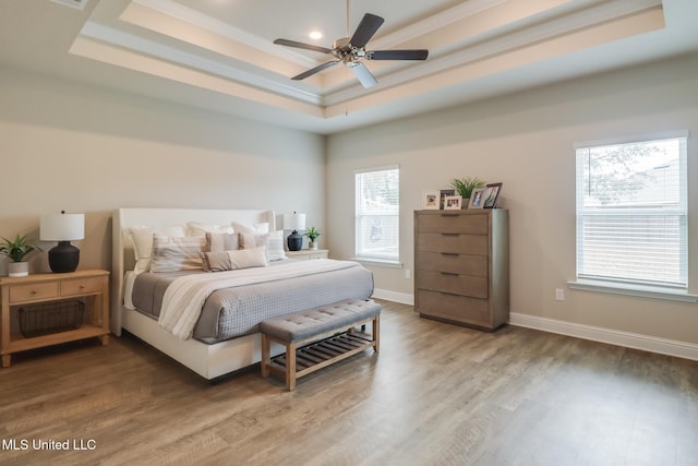 bedroom featuring a raised ceiling, hardwood / wood-style flooring, and ceiling fan