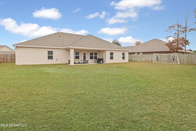 back of house with a patio area and a lawn