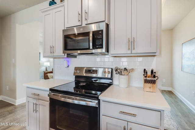 kitchen featuring tasteful backsplash, stainless steel appliances, and light wood-type flooring